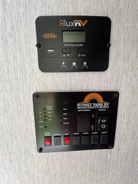 A rlux rv is displayed on a wall next to a control panel.