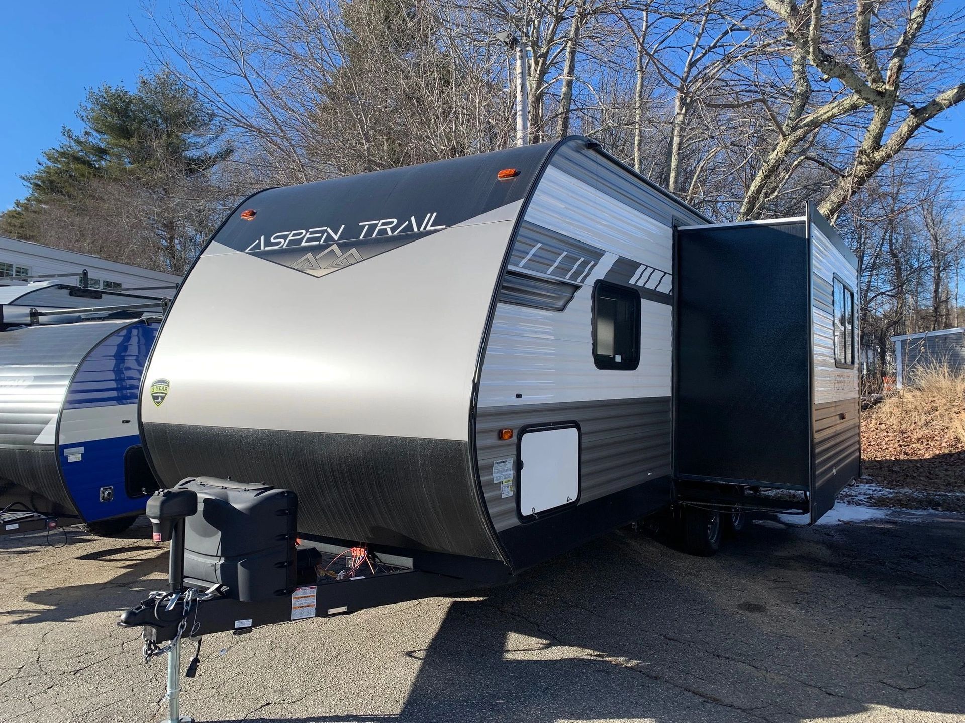 A small trailer is parked on the side of the road.