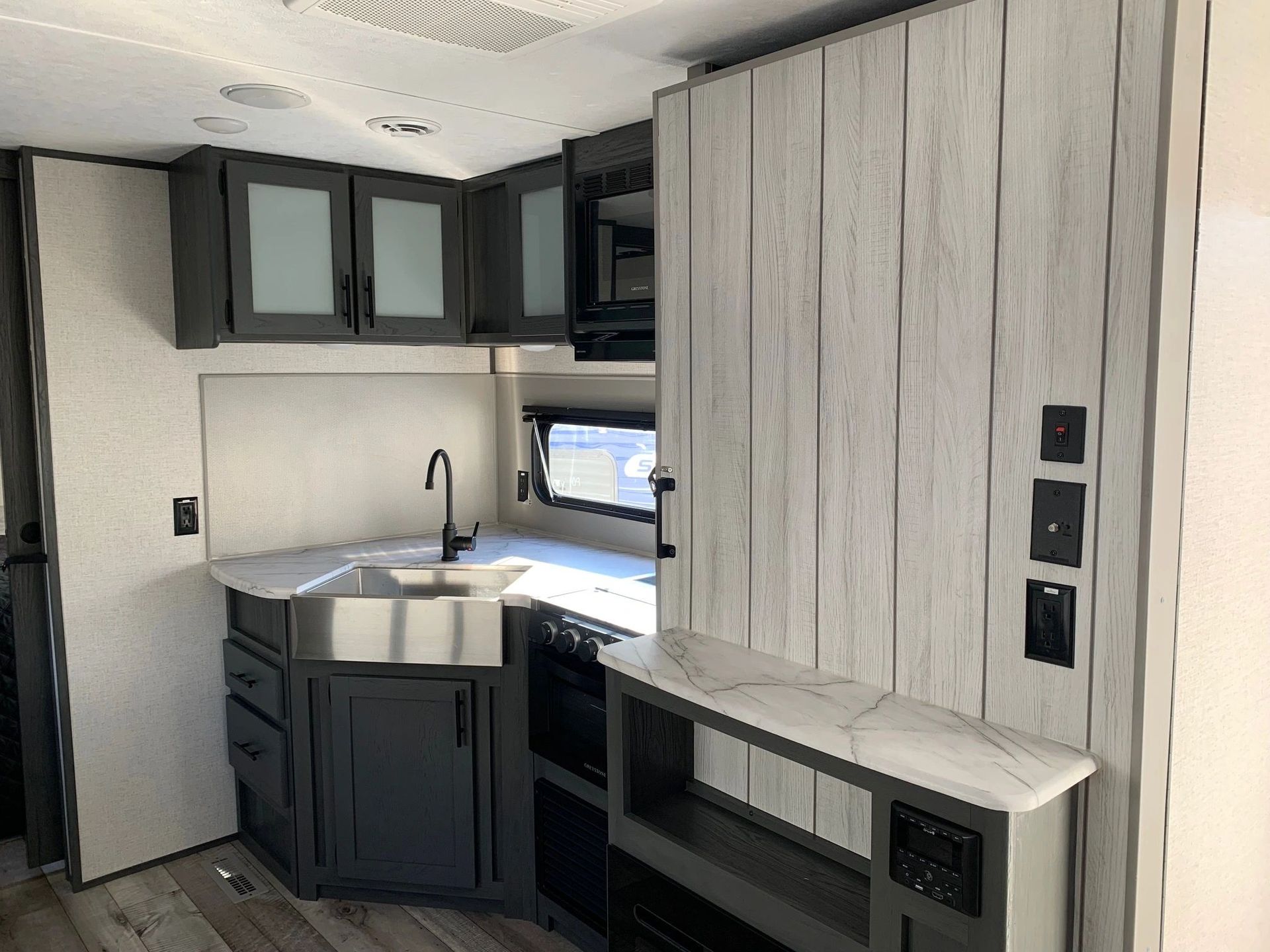 A kitchen in a rv with stainless steel appliances and a sink.