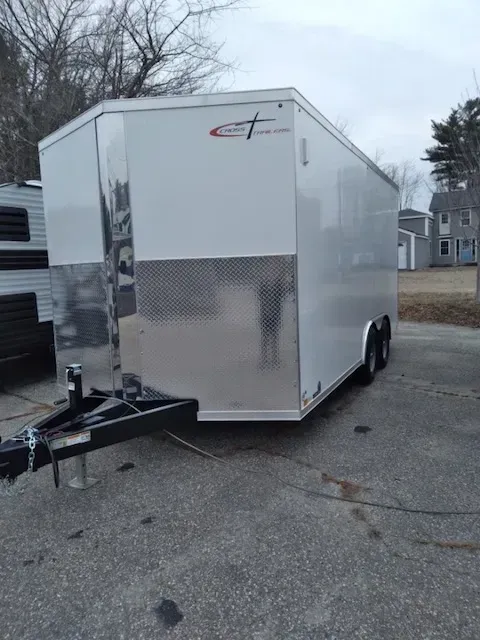 A white trailer is parked on the side of the road.