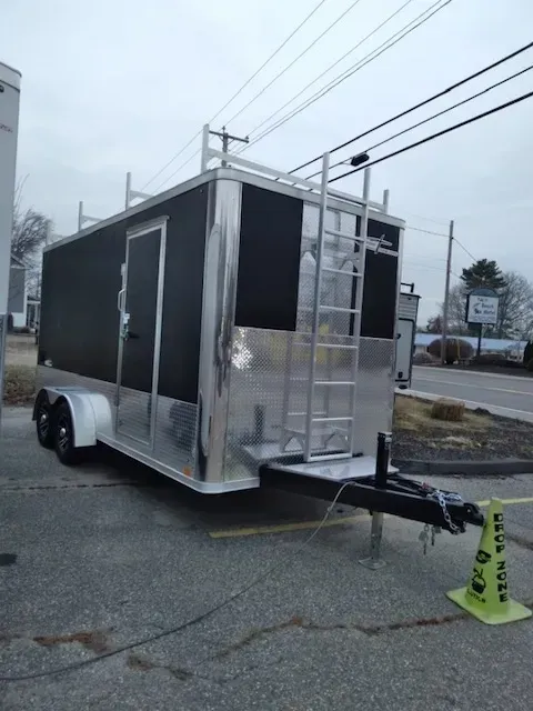 A trailer with a ladder attached to it is parked on the side of the road