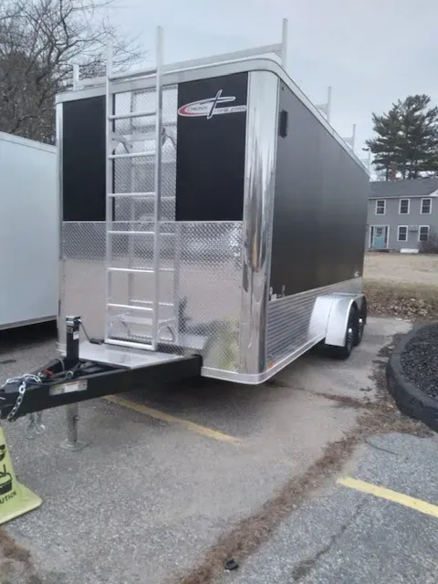 A trailer with a ladder attached to it is parked in a parking lot.