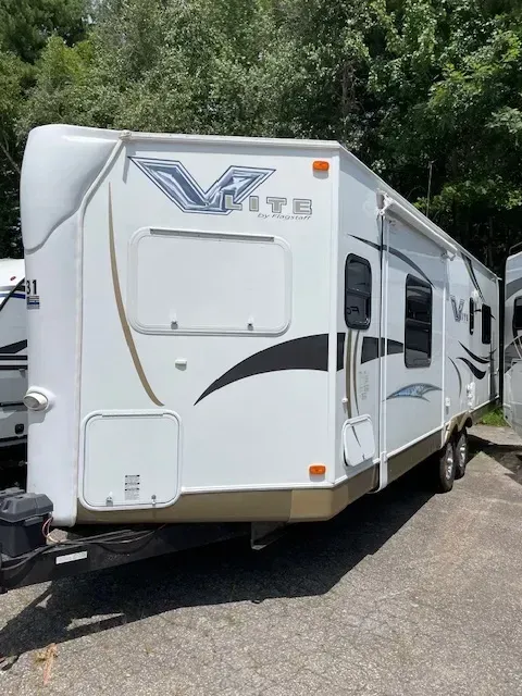 A white rv is parked on the side of the road.