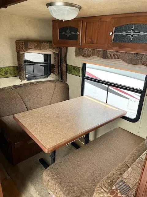 A rv with a table and a couch in it.