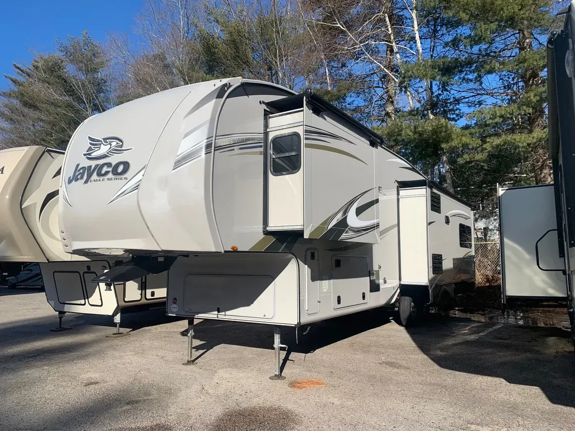 A white rv is parked in a parking lot.