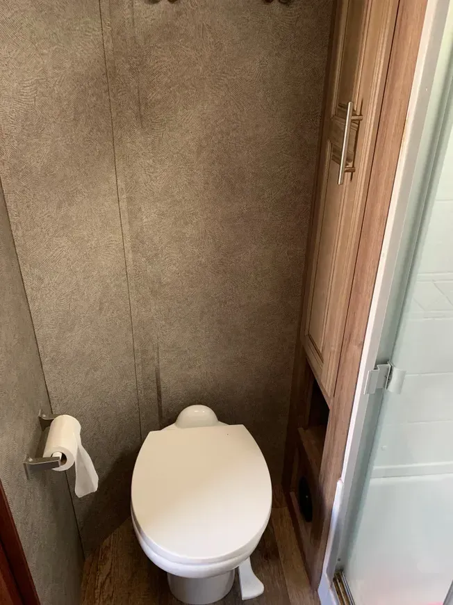 A bathroom with a toilet and a paper towel holder.