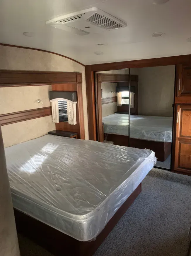 A bedroom with a mattress and a mirror