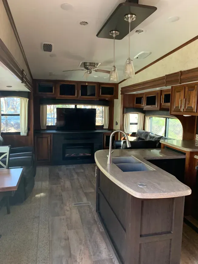 A kitchen with a sink and a television on the wall