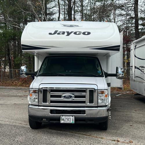 A white jayco rv is parked in a parking lot.