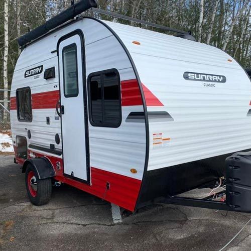 A red and white trailer is parked on the side of the road.