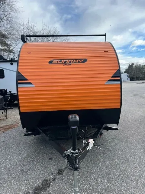 An orange and black trailer is parked in a parking lot.