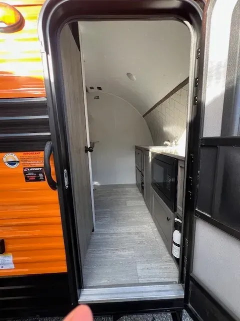 A person is standing in the doorway of a trailer.