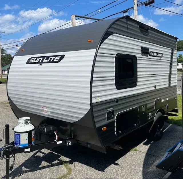 A sun lite trailer is parked on the side of the road