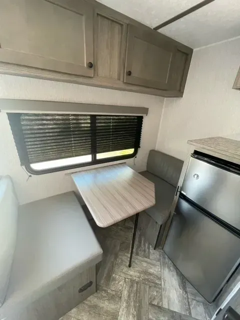 There is a table and a refrigerator in the room.