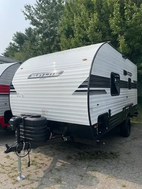 A white and black trailer is parked in a parking lot.