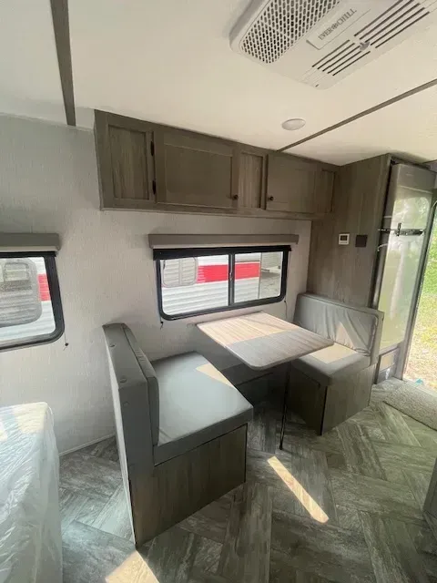 The inside of a rv with a table and benches.