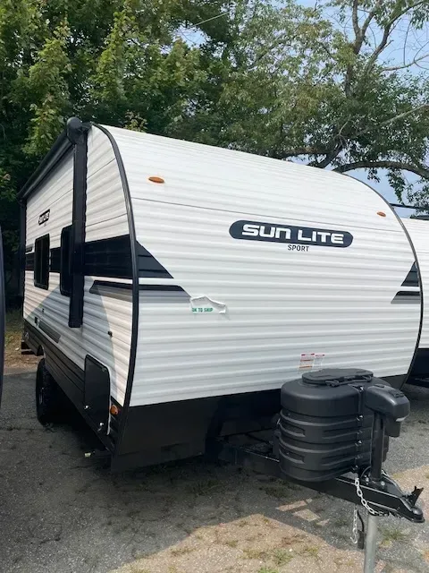 A white sun lite trailer is parked in a parking lot.