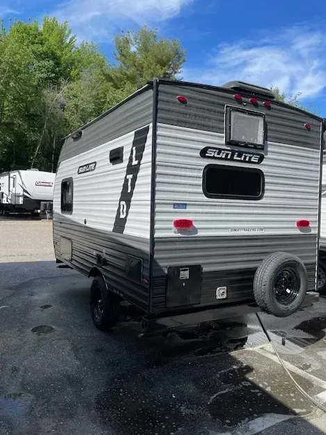 A small trailer is parked in a parking lot.