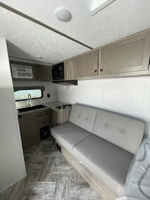 A rv with a couch and a kitchen in it.