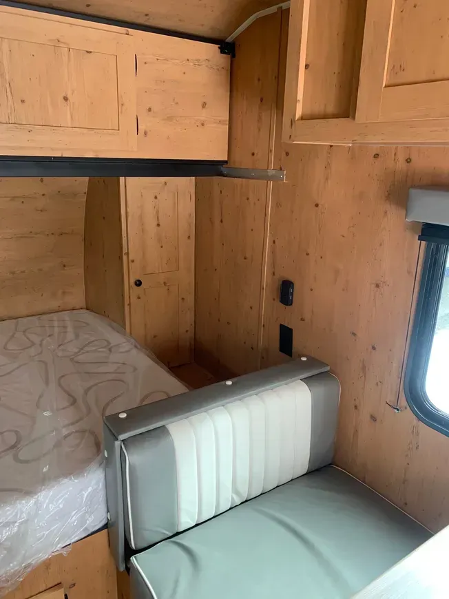 A camper with a bed and a couch in it.
