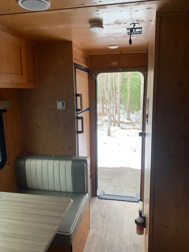 The inside of a camper with a table and a bench.