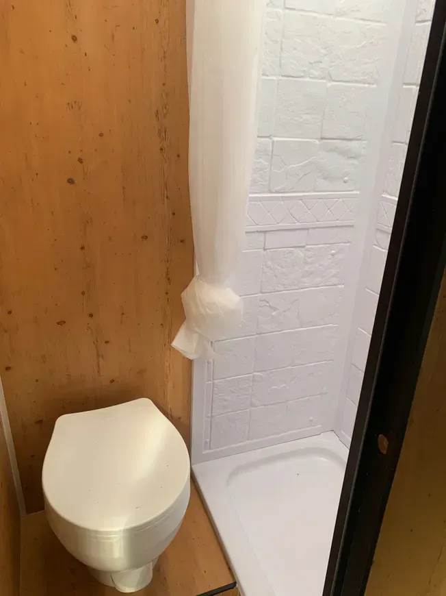 There is a toilet and a shower in the bathroom.