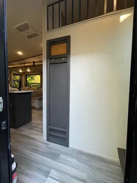 A hallway in a house with a door and a window.