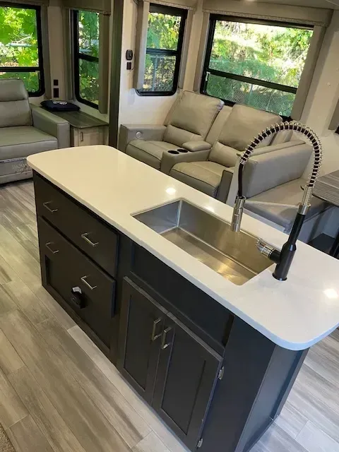 A kitchen in a rv with a sink and a faucet