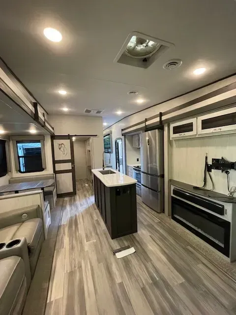 The inside of a rv with a large island in the middle of the room.