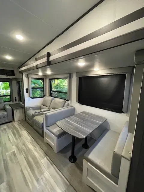 A living room in a rv with a table and couch.