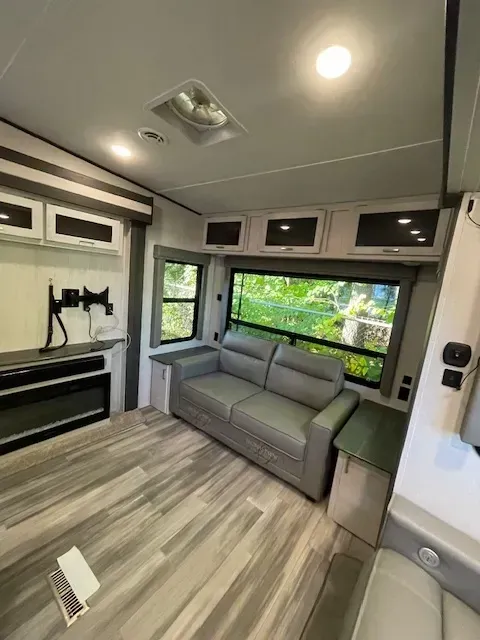 A living room in a rv with a couch and a television.
