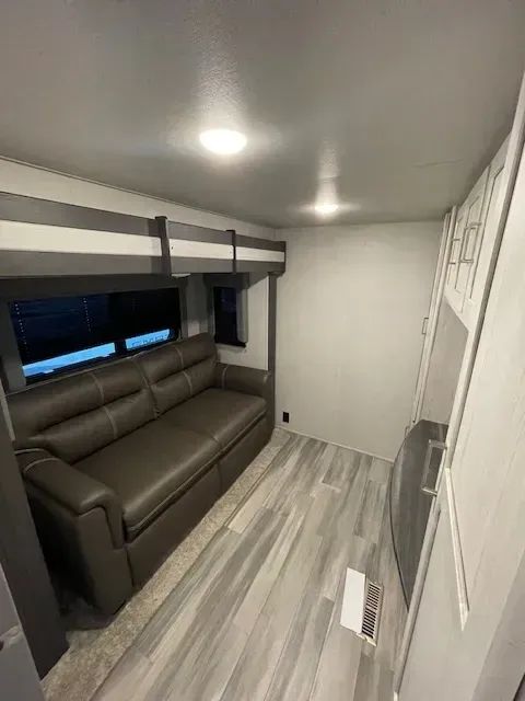 A living room with a couch and bunk beds.