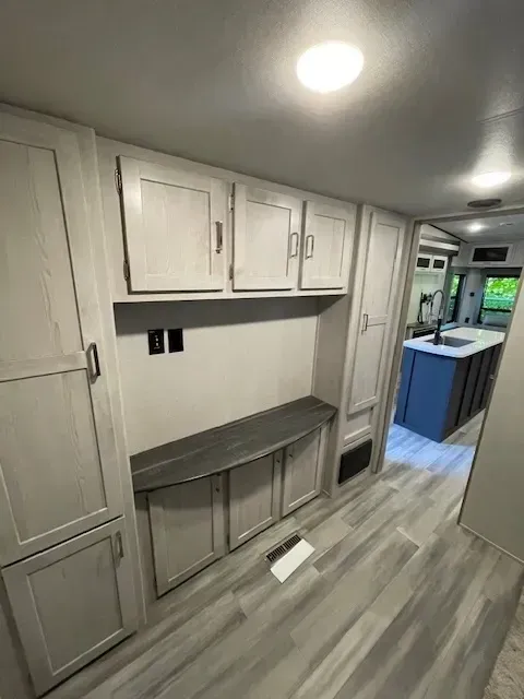 A rv with a lot of cabinets and a table in the middle of the room.