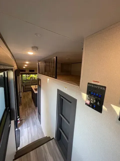 A hallway with stairs leading up to a bedroom in a rv.