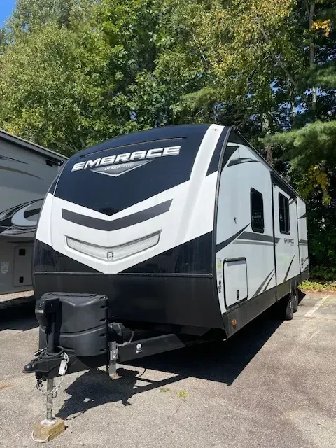 A black and white trailer is parked in a parking lot.