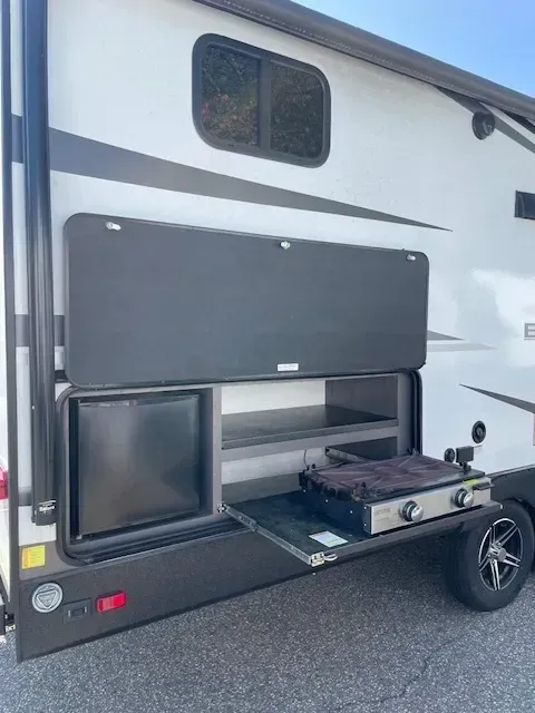 A rv with a stove and a refrigerator in the back.
