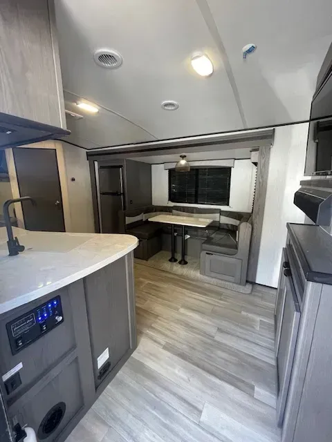 A kitchen in a trailer with a table and chairs.
