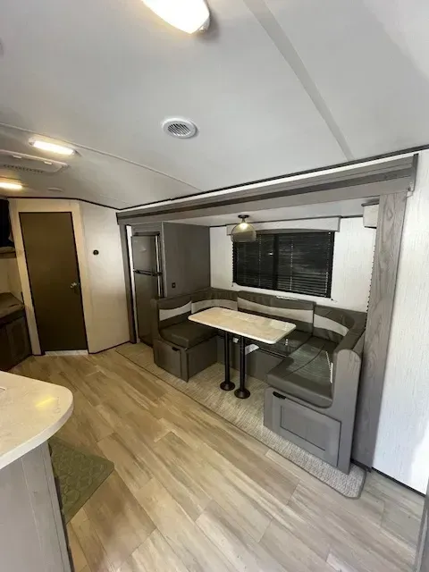 A living room with a table and benches in a trailer.
