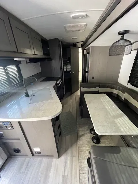 The inside of a rv with a table and couch.