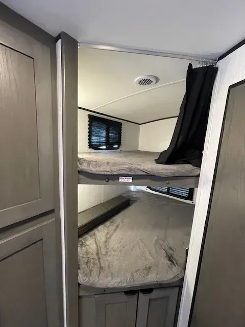 A bunk bed in a rv with a mattress on top of it.