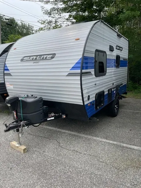 A blue and white trailer is parked in a parking lot.