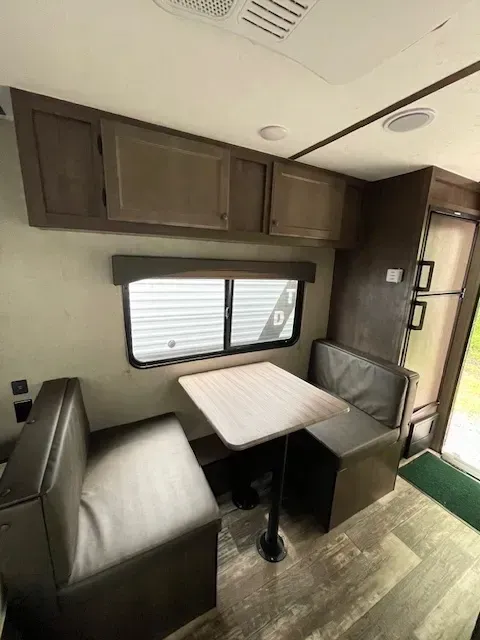 A rv with a table and benches inside of it.