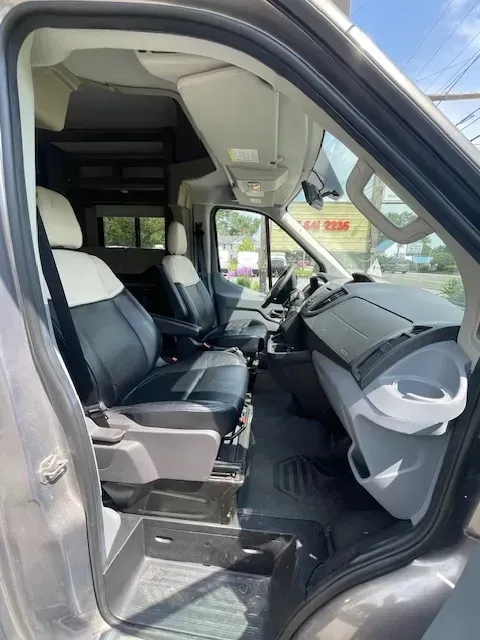The inside of a van with the door open and the seats up.