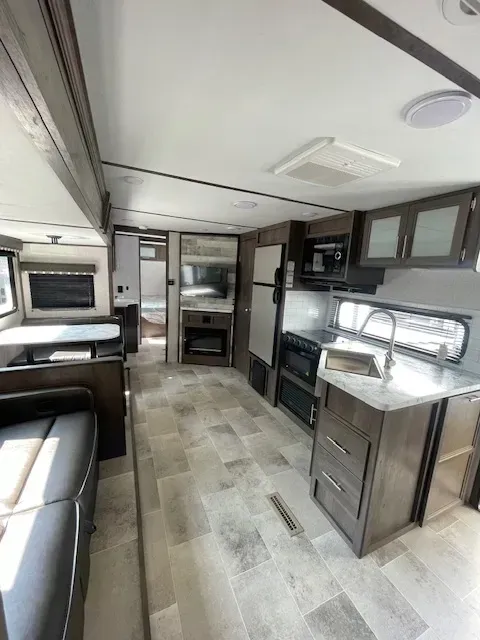 A rv with a kitchen , dining room , and living room.