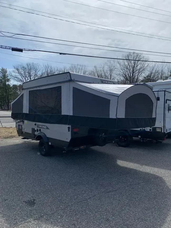 A camper trailer is parked on the side of the road.
