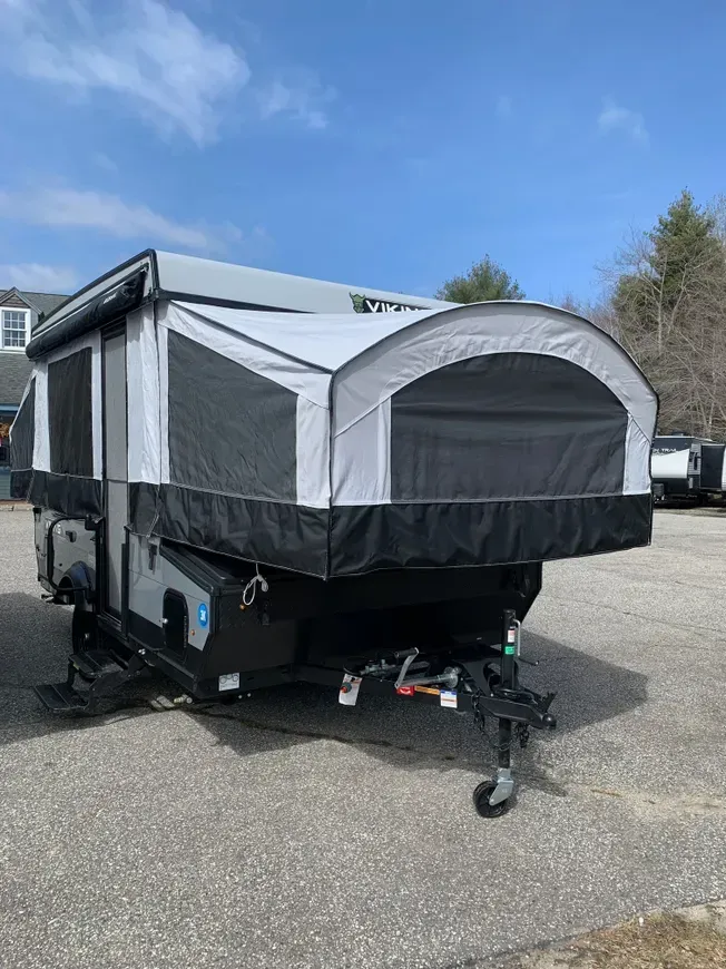 A pop up camper is parked in a parking lot.