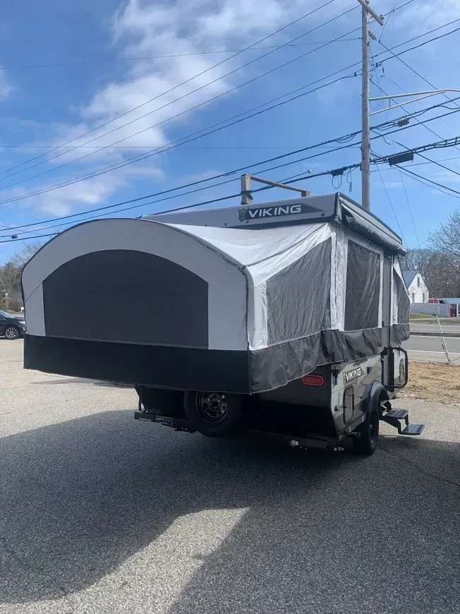 A camper trailer is parked on the side of the road.