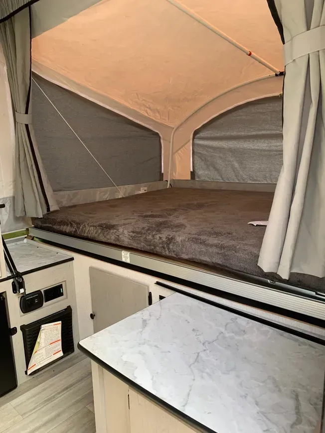 A camper with a bed and a table in it.