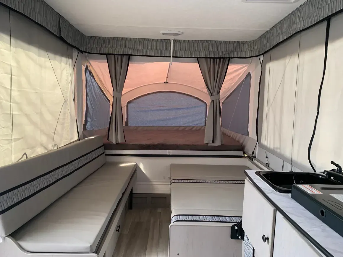The inside of a camper with a table and a sink
