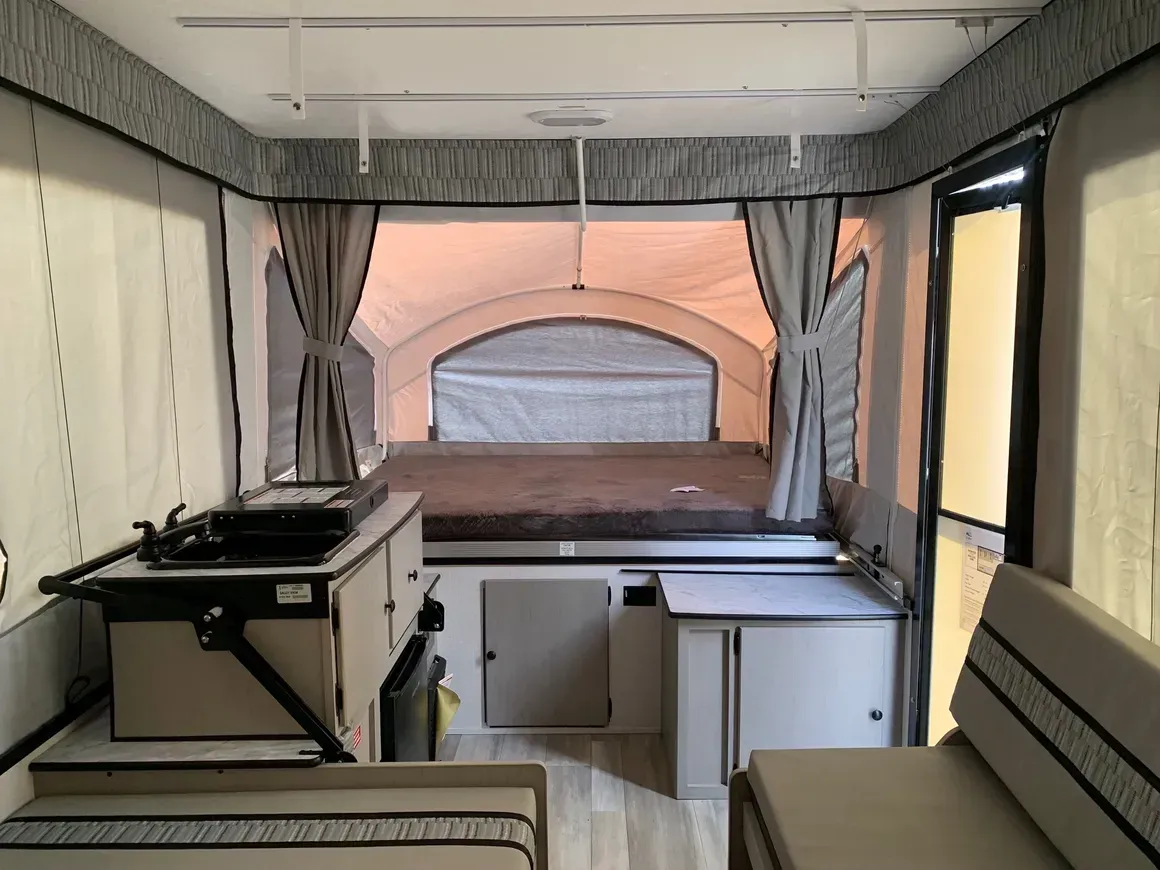 The inside of a camper with a bed and a sink